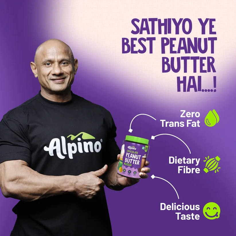 Man holding an Alpino peanut butter jar with dietary icons on a purple background