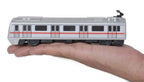 Side view of a silver metro train toy with red stripe, shown resting on a hand