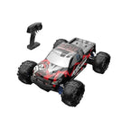 Remote control 4WD monster truck driving off-road on rough terrain.
