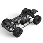 Black RC crawler chassis frame with blue shocks and large tread tires