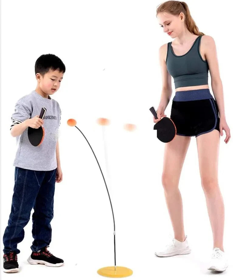Kids using table tennis paddles with freestanding training stand and orange balls