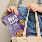 Purple potato stix snack bag held with beige tote over denim jeans